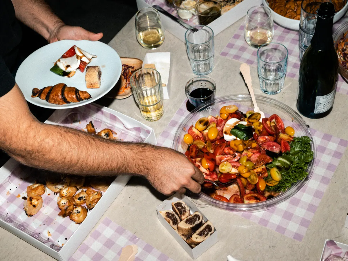 אורחים מגישים לעצמם קפרזה ומאפים משולחן האירוח